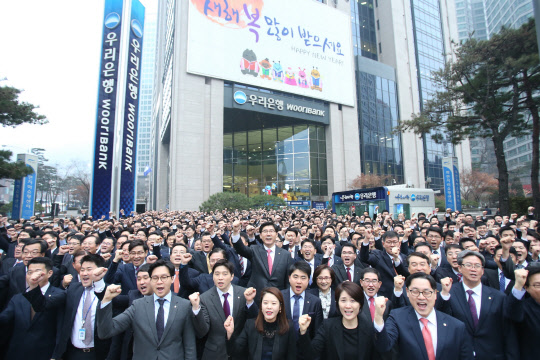 우리은행은 2일 2017년 새해 첫 공식행사로 이광구 은행장을 비롯한 임직원 1500여명이 참석한 가운데 결의다짐 행사를 개최했다. 사진은 이광구 행장과 임직원들이 서울 중구 명동 본사앞에 모여 화이팅을 외치는 모습. 우리은행 제공.